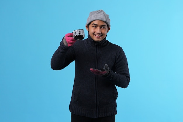 Jonge aantrekkelijke man in winterkleding met mok koffie