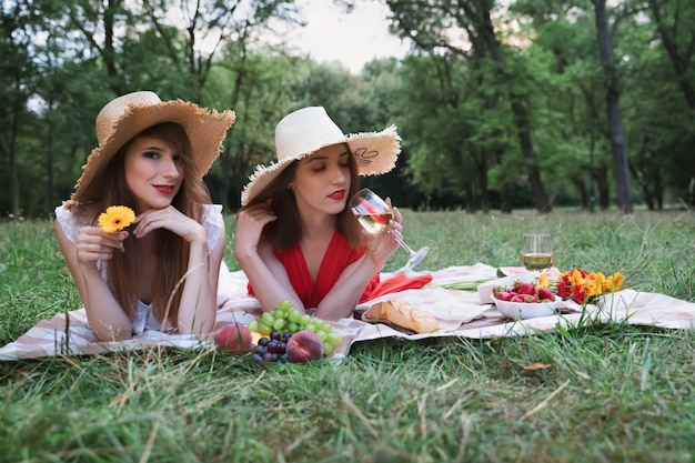 Foto jonge aantrekkelijke meisjes op een picknick in een stadspark.