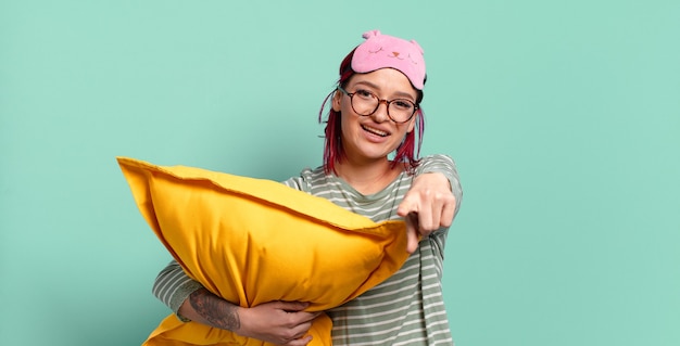 Foto jonge aantrekkelijke roodharige vrouw die op camera wijst met een tevreden, zelfverzekerde, vriendelijke glimlach, jou kiest en pyjama draagt.