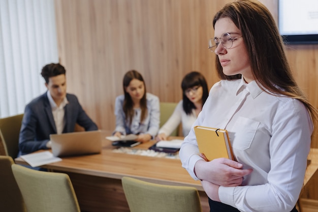 Jonge aantrekkelijke stijlvolle kantoormedewerker vrouw in glazen met een laptop in handen