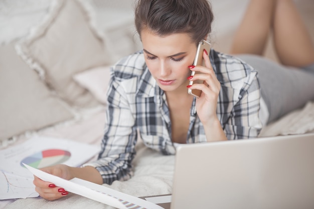 Jonge aantrekkelijke vrouw die bij laptop werkt