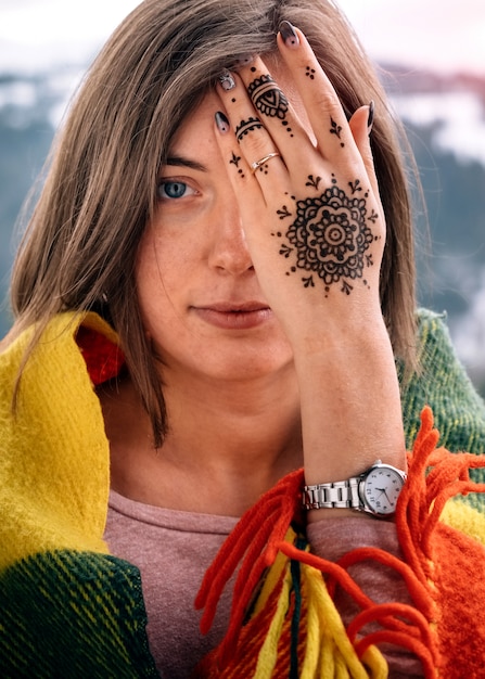 Foto jonge aantrekkelijke vrouw die oog behandelt met mehndihand