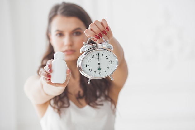 Jonge aantrekkelijke vrouw die pillen op het juiste moment neemt