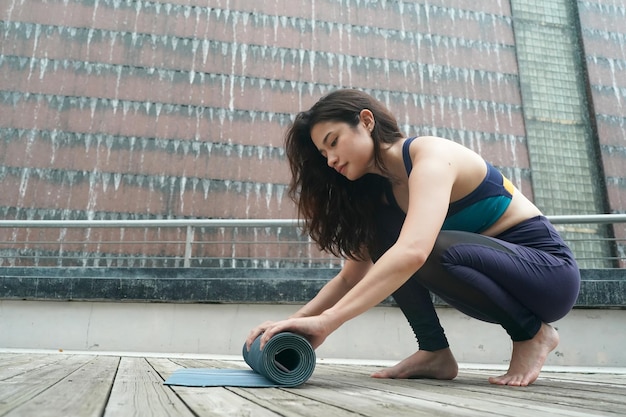 Jonge aantrekkelijke vrouw die uitrekkende yogaoefening in het park doet