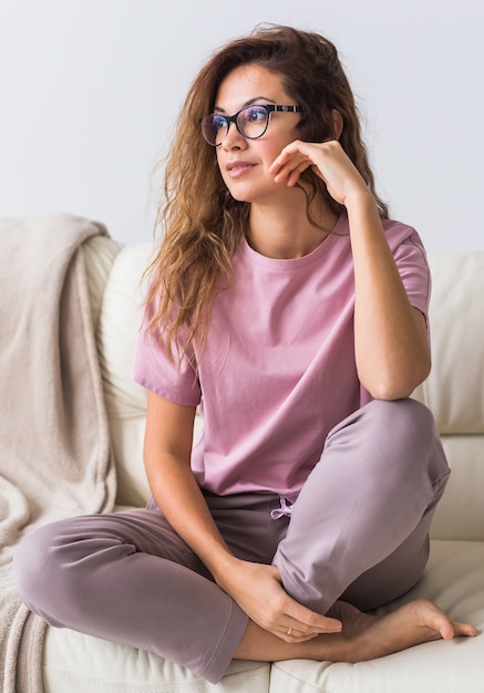 Jonge aantrekkelijke vrouw gekleed in prachtige kleurrijke pyjama die zich voordeed als een model in haar woonkamer