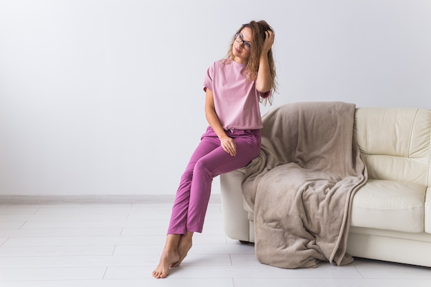 Jonge aantrekkelijke vrouw gekleed in prachtige kleurrijke pyjama die zich voordeed als een model in haar woonkamer