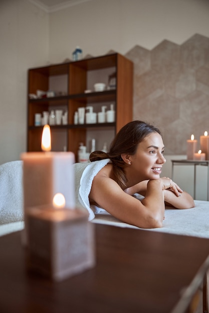 Foto jonge aantrekkelijke vrouw in massagesalon heeft schoonheids- en gezondheidszorgprocedures