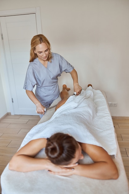 Jonge aantrekkelijke vrouw in massagesalon heeft schoonheids- en gezondheidszorgprocedures
