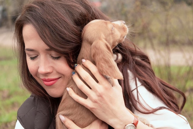 Jonge aantrekkelijke vrouw knuffelt een schattig cocker-spaniëlpuppy. Een nieuw schattig familielid. Dierenverzorging en huisdierconcept