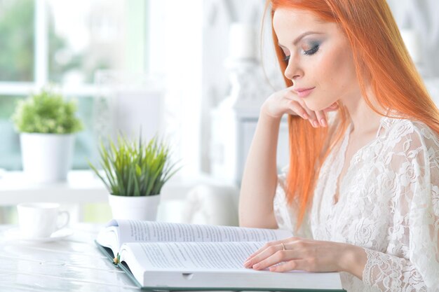 Jonge aantrekkelijke vrouw met boek in de ochtend