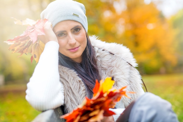 Jonge aantrekkelijke vrouw met boeket herfstbladeren in de hand. Val.