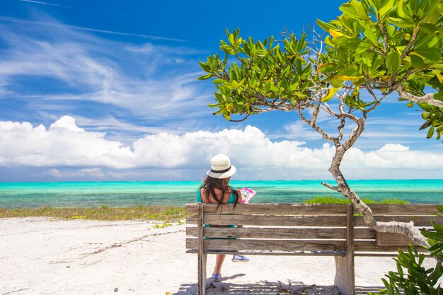 Jonge aantrekkelijke vrouw op de bank tijdens de zomervakantie