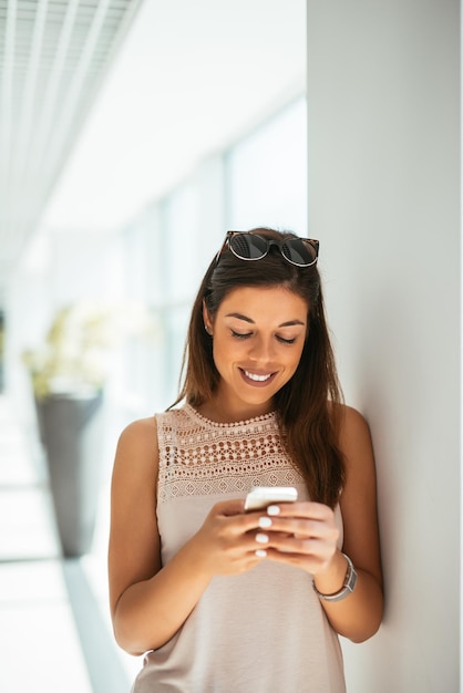 Jonge aantrekkelijke zakenvrouw sms't op de luchthaven.