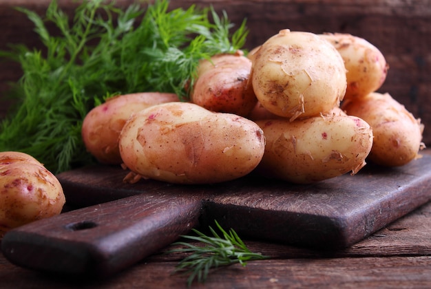 Jonge aardappelen in een houten plaat op een houten achtergrond