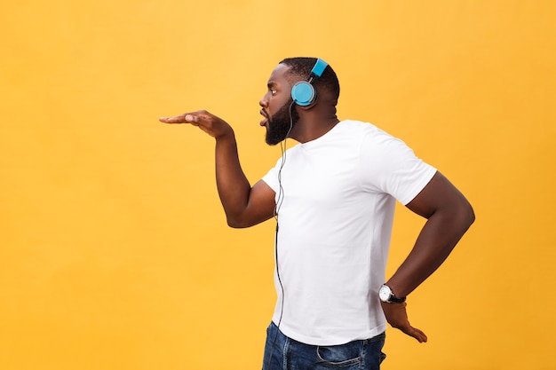 Jonge african american man met hoofdtelefoon en geniet van muziek dansen