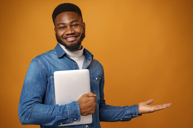 Jonge African American man met laptop tegen