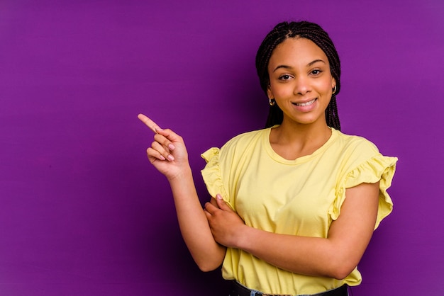 Jonge african american vrouw geïsoleerd op gele muur Jonge african american vrouw geïsoleerd op gele muur glimlachend vrolijk wijzend met wijsvinger weg.