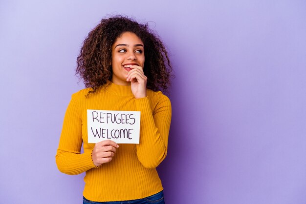 Jonge African American vrouw met een vluchtelingen welkom bordje geïsoleerd