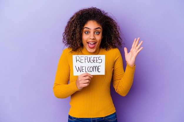 Jonge African American vrouw met een vluchtelingen welkom bordje geïsoleerd