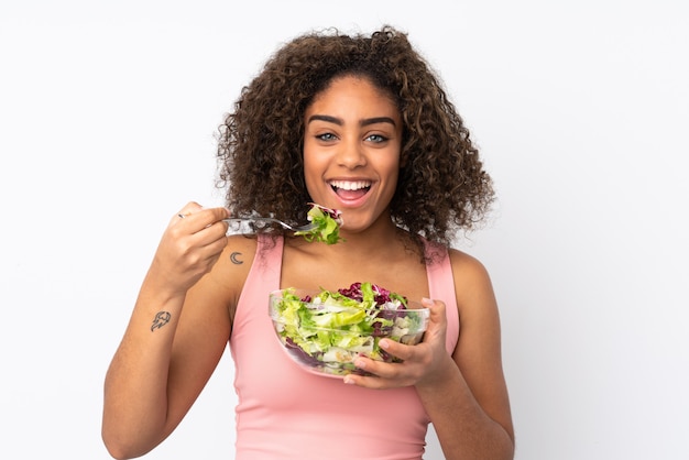 Jonge African American vrouw met salade geïsoleerd op wit