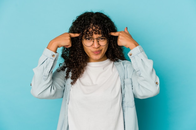 Jonge afrikaanse amerikaanse afro geïsoleerde vrouw concentreerde zich op een taak, met wijsvingers die het hoofd richten.