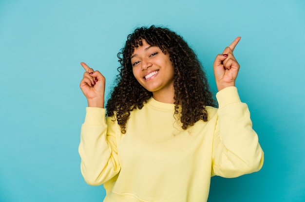 Jonge afrikaanse amerikaanse afrovrouw die naar verschillende exemplaarruimten wijst, een van hen kiest, met vinger toont.