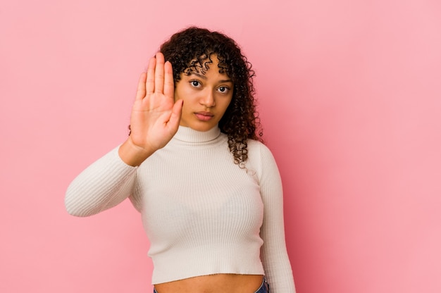 Jonge afrikaanse amerikaanse afrovrouw geïsoleerde status met uitgestrekte hand die stopbord toont, dat u verhindert.