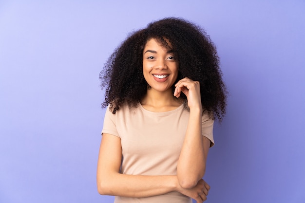 Jonge Afrikaanse Amerikaanse vrouw die bij het purpere lachen wordt geïsoleerd