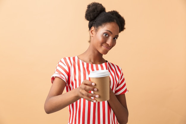 Jonge afrikaanse amerikaanse vrouw die in vrijetijdskleding document kop met geïsoleerde koffie houdt