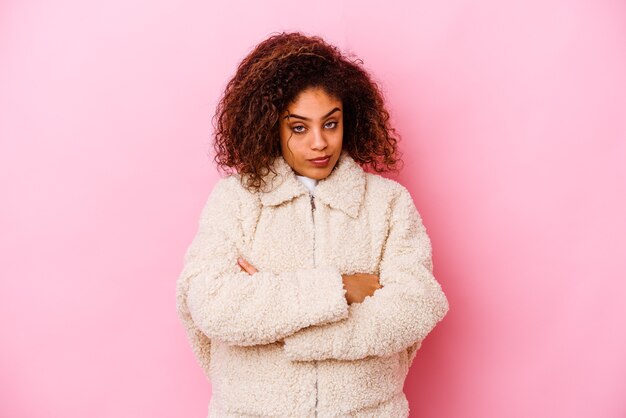 Jonge afrikaanse amerikaanse vrouw die op roze muur wordt geïsoleerd die verveeld, vermoeid is en een ontspannende dag nodig heeft.