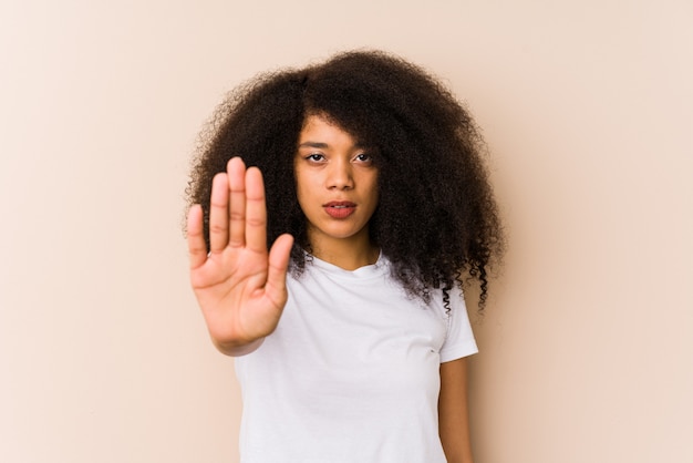 Jonge Afrikaanse Amerikaanse vrouw die zich met uitgestrekte hand bevindt die eindeteken toont, dat u verhindert.