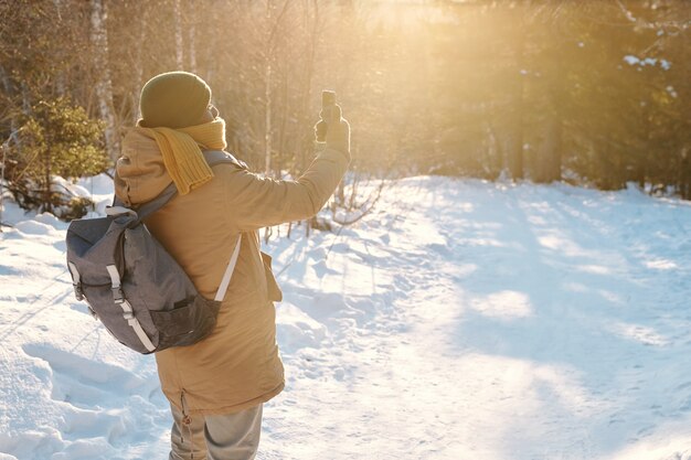 Jonge afrikaanse backpacker in winterkleding die selfie maakt