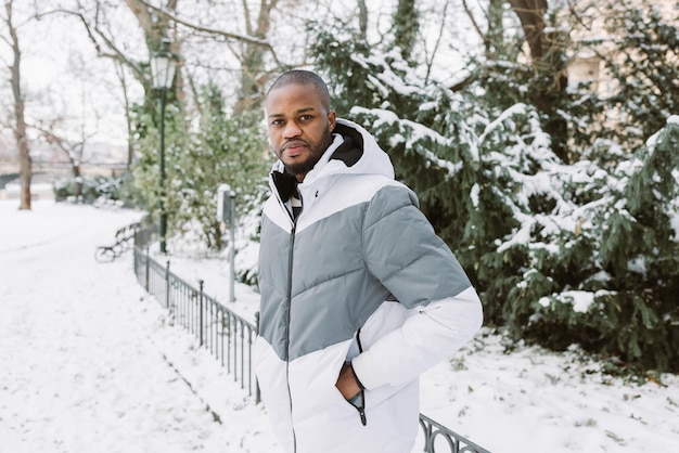 Jonge Afrikaanse man in park sneeuw winterseizoen stad portret