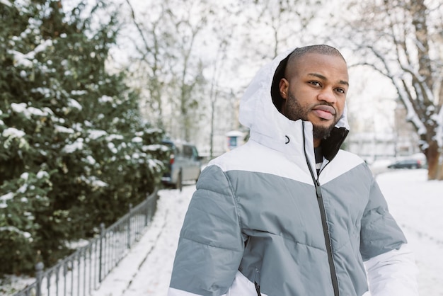 Jonge Afrikaanse man in park sneeuw winterseizoen stad portret