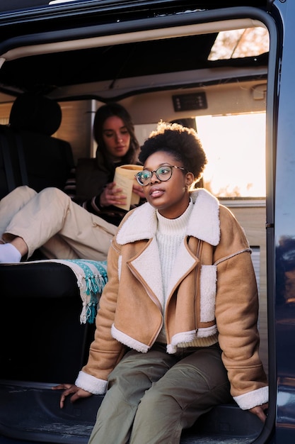 Jonge Afrikaanse vrouw bij zonsondergang in camper