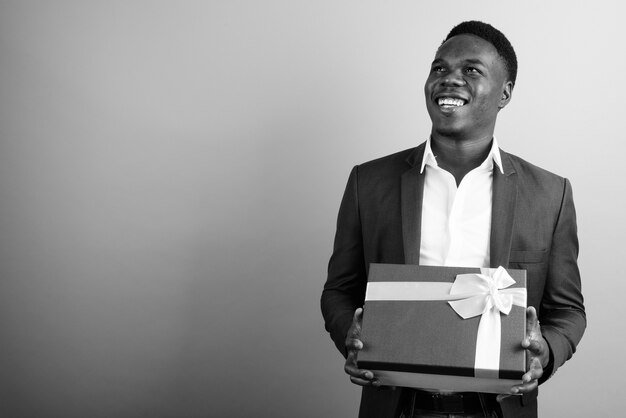 jonge Afrikaanse zakenman draagt pak tegen witte muur. zwart en wit