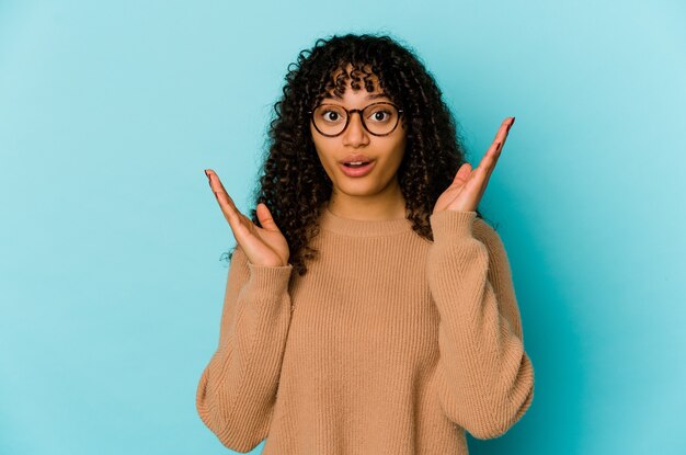 Jonge afro-amerikaanse afro vrouw geïsoleerd verrast en geschokt.