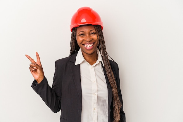 Jonge Afro-Amerikaanse architect vrouw geïsoleerd op een witte achtergrond blij en zorgeloos met een vredessymbool met vingers.