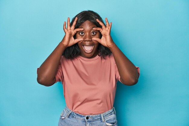 Jonge afro-amerikaanse bochtige vrouw die de ogen openhoudt om een kans op succes te vinden