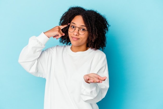 Jonge afro-amerikaanse gemengd ras vrouw geïsoleerd afleggen van een eed, hand leggen op de borst.