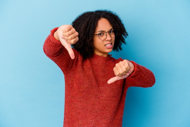 Jonge Afro-Amerikaanse gemengd ras vrouw geïsoleerd duim omlaag tonen en afkeer uiten.