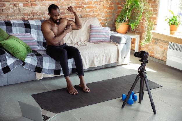 Jonge Afro-Amerikaanse man die thuis online fitnesscursussen geeft