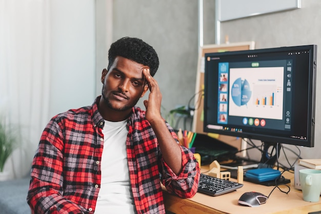 Jonge afro-amerikaanse man freelancer lijdt aan hoofdpijn na hard werken met laptopcomputer thuis geestelijke gezondheidszorg concept