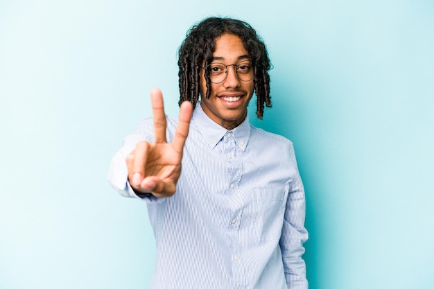Jonge Afro-Amerikaanse man geïsoleerd op blauwe achtergrond vrolijk en zorgeloos met een vredessymbool met vingers