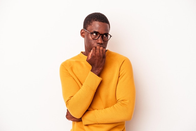 Jonge Afro-Amerikaanse man geïsoleerd op een witte achtergrond vingernagels bijten, nerveus en erg angstig.