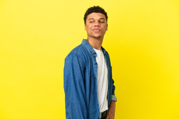 Jonge Afro-Amerikaanse man geïsoleerd op gele achtergrond. Portret