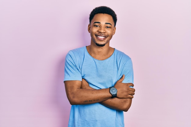 Jonge afro-amerikaanse man met casual blauw t-shirt blij gezicht lachend met gekruiste armen kijkend naar de positieve persoon van de camera