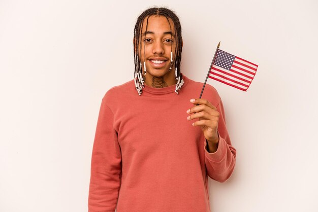 Jonge Afro-Amerikaanse man met een Amerikaanse vlag geïsoleerd op een witte achtergrond gelukkig lachend en vrolijk