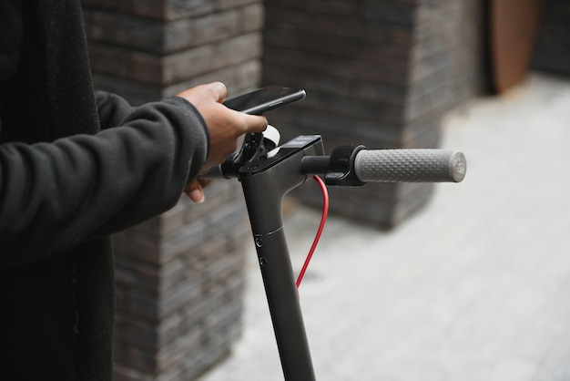 Jonge Afro-Amerikaanse man met elektrische scooter in de stad