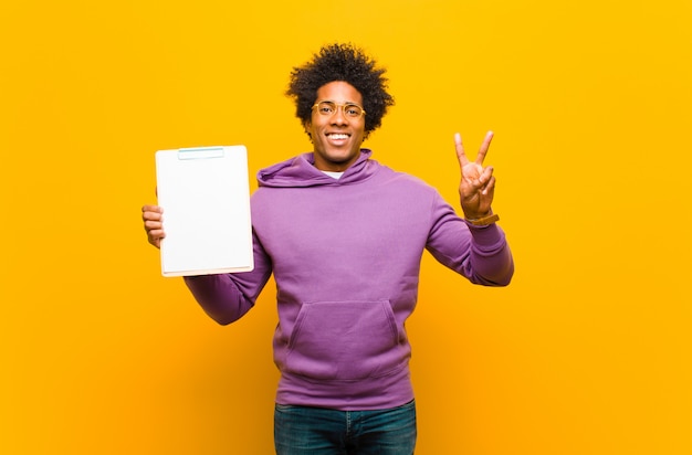 Jonge Afro-Amerikaanse man tegen oranje achtergrond